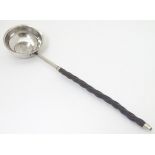 A 19thC toddy ladle with white metal bow hanging inset Geo III coin to centre.