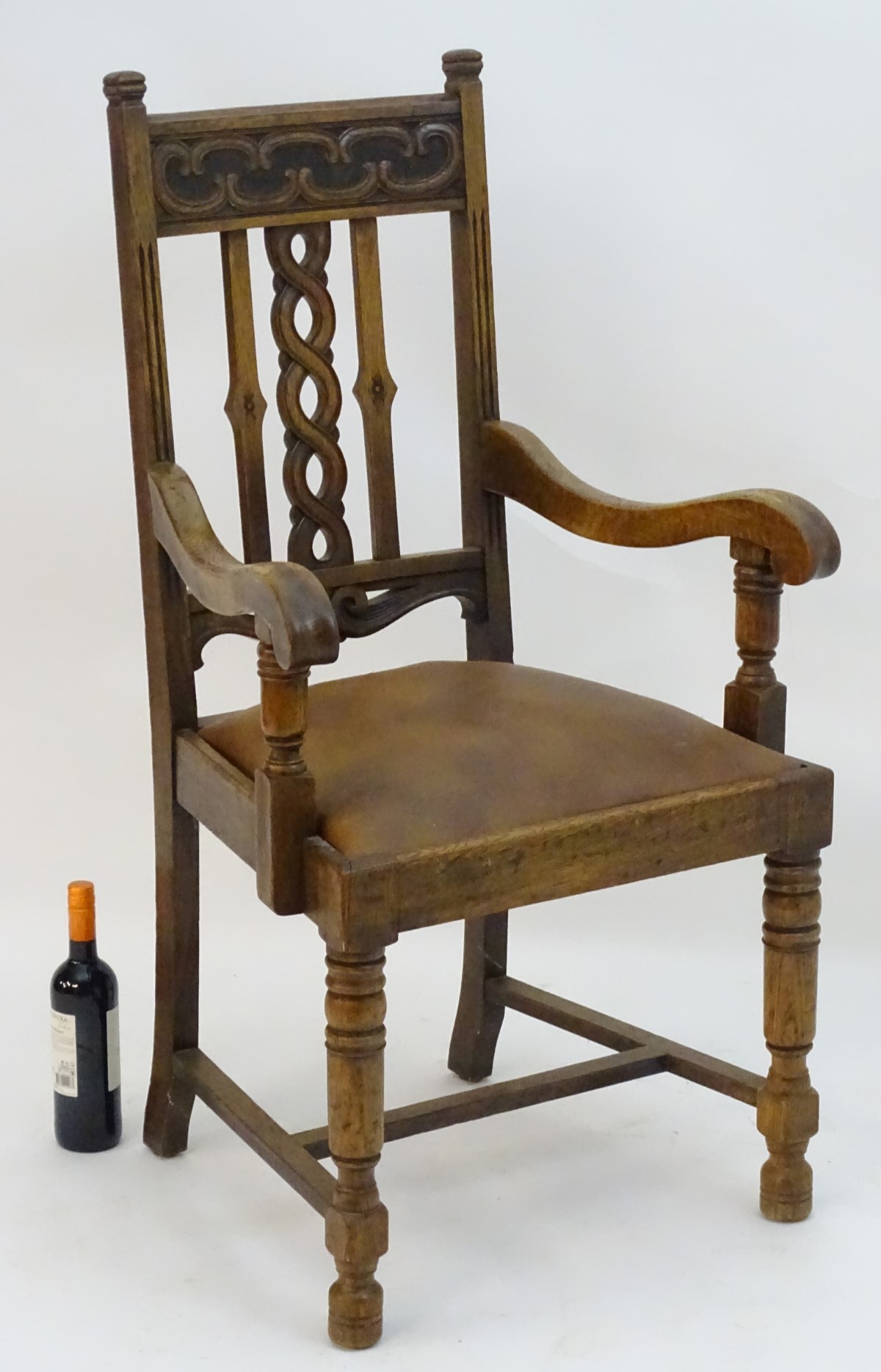 An early 20thC oak open armchair with a Celtic style carved top rail and back ress, - Image 2 of 8