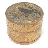A 20thC cylindrical wooden box, with carved bird and blossom detail to top. Signed under E. Storey.