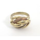 A 9ct gold ring with stylised three coloured gold knot decoration to top. Ring size approx. R 1/2.