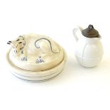 A Welsh pottery lidded butter dish with recumbent cow decoration with hand painted blue details.