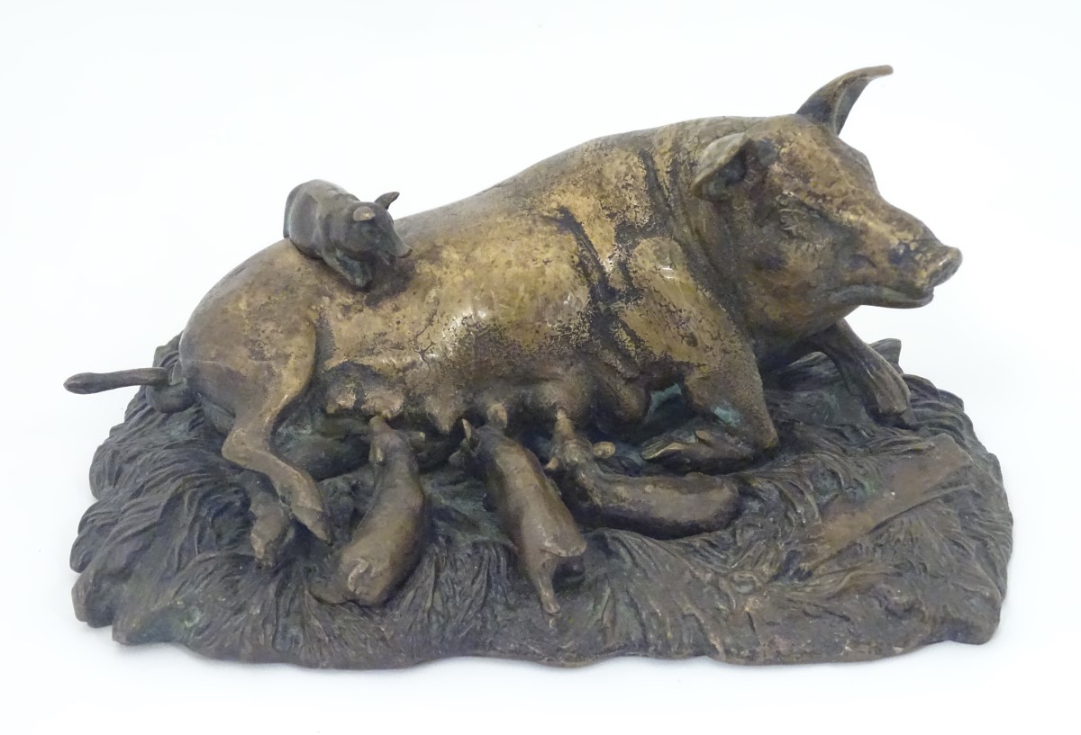 A bronze model of a recumbent pig with piglets on a base modelled as a bed of straw. Approx.