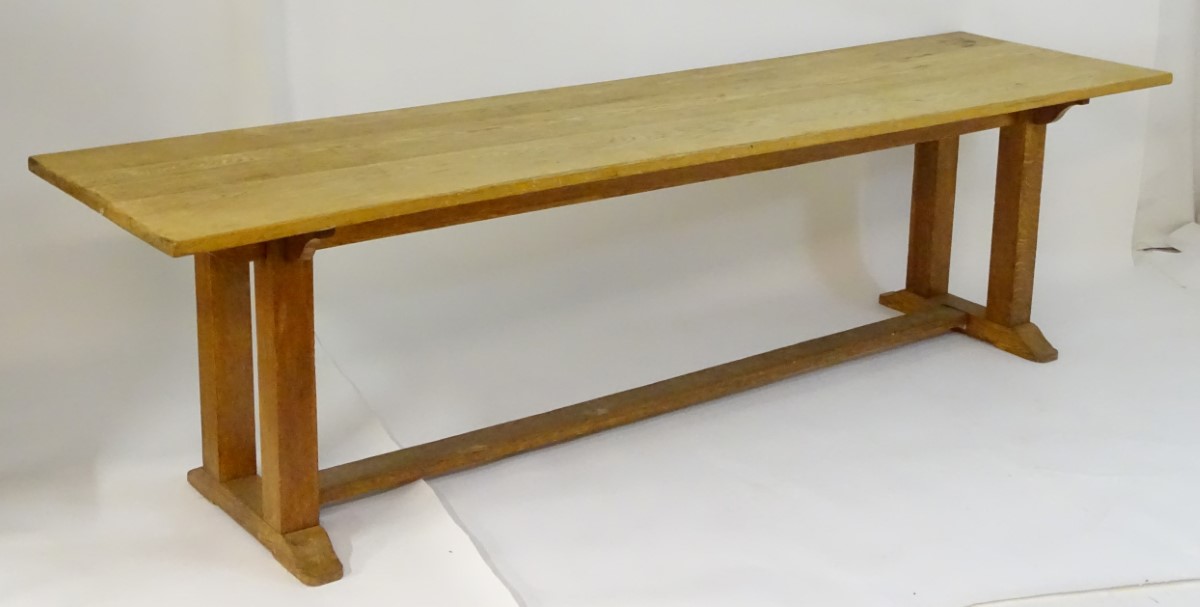 An early 20thC large Arts & Crafts style oak dining / refectory table with a rectangular top above