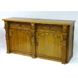 A mid 20thC oak sideboard with a rectangular top above two frieze drawers with decorative carving