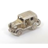 A novelty silver pendant charm formed as a vintage motor car with articulated wheels. Approx.