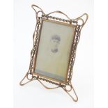 A Victorian brass picture frame with wirework decoration and an easel back support. Approx.