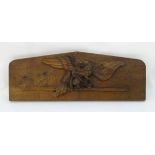 A carved oak plaque depicting an eagle with a snake grasped in its talons.