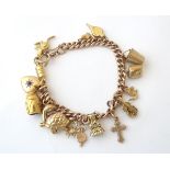 A 9ct gold and gilt metal charm bracelet set with various charms.