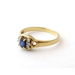 An 18ct gold ring set with sapphire flanked by diamonds.