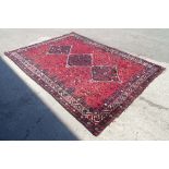 Carpet / Rug : A red ground rug with banded and foliate decoration and central geometric detail.