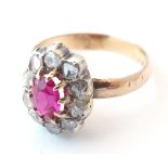 A gold ring set with central ruby bordered by diamonds (unmarked, tests as 14ct). Ring size approx.