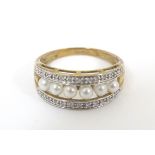 A 9ct gold ring set with a band of pearls flanked by bands of chip set diamonds. Ring size approx.
