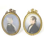 A pair of 19thC cabinet portrait miniatures, in easel back oval frames with scrolling decoration.