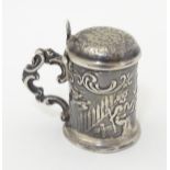 A novelty miniature Continental silver pill box formed as a lidded tankard with cast putti