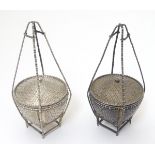 A pair of white metal pot and covers formed as a small woven lidded baskets .