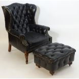 A mid 20thC Chesterfield style wingback armchair and footstool,