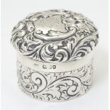 A silver pot of circular form with screw top having engraved and embossed acanthus scroll