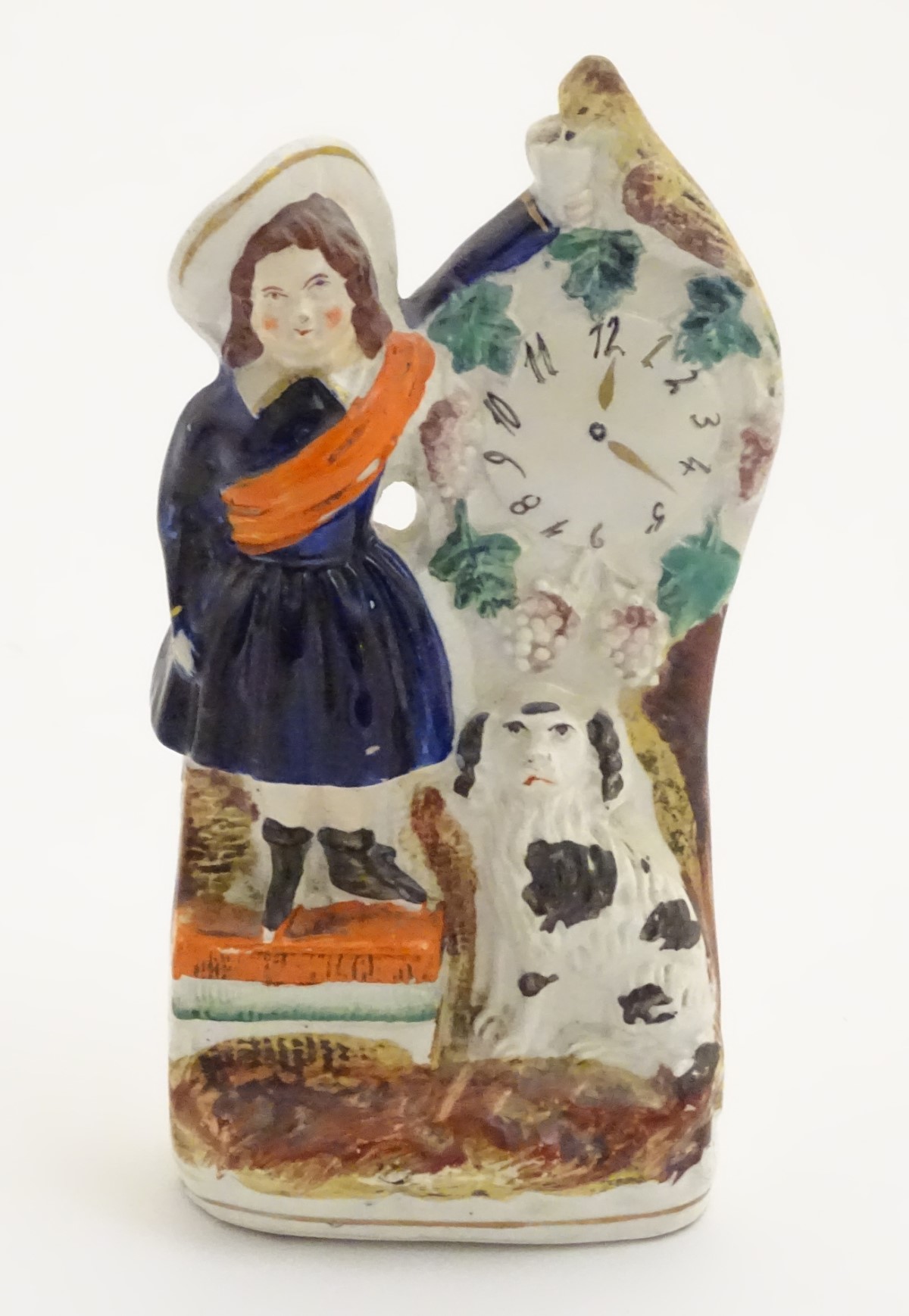 A Victorian Staffordshire pottery flatback model of a woman wearing a sash feeding a bird next to a