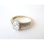 A 14ct gold ring set with central cubic zirconia flanked by further cubic zirconias.