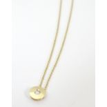 An 14ct gold pendant chain, the pendant set with central diamond.