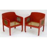 A pair of Chinese style red painted armchairs with pierced gilt painted sides and caned seats.