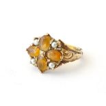 A 9ct gold ring set with citrines and seed pearls with acanthus scroll decoration to shoulders.