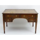 An early 20thC four drawer mahogany desk with an inset leather top,