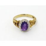 An 18ct gold ring set with central amethyst bordered by diamonds.