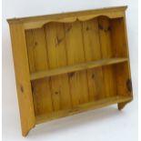 A mid 20thC set of pine wall shelves with a moulded cornice above two shelves.