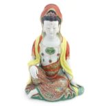 A Chinese famille rouge ceramic figure of a seated lady with famille verte enamel decoration to