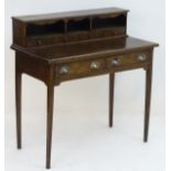 A late 19thC oak writing desk with a moulded top section above pigeon holes and short fitted