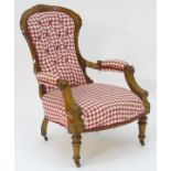A late 19thC open armchair with a shell carved frame above a deep buttoned back rest and sprung