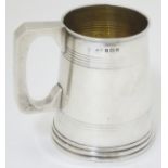 A silver mug / Christening cup of tankard form with banded decoration.