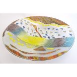 A large studio art glass charger decorated with fused coloured glass detail.