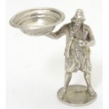 A novelty white metal pipe tamper of figural form depicting a figure wearing a fisherman's hat and