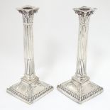 A pair of silver candlesticks of Corinthian column form.