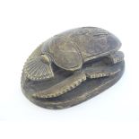 An ancient Egyptian style carved wooden heart scarab beetle amulet the base inscribed with