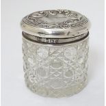 A cut glass dressing table pot with silver top hallmarked Birmingham 1921 maker A J Pepper & Co.