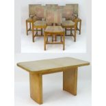 An early 20thC oak Heal's dining suite comprising an extending Heals dining table and six (4+2)