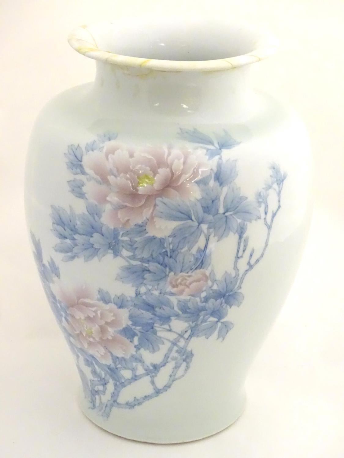 A Japanese Inoue Ryosai baluster vase with a flared rim, decorated with blue branches and leaves and