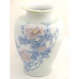 A Japanese Inoue Ryosai baluster vase with a flared rim, decorated with blue branches and leaves and