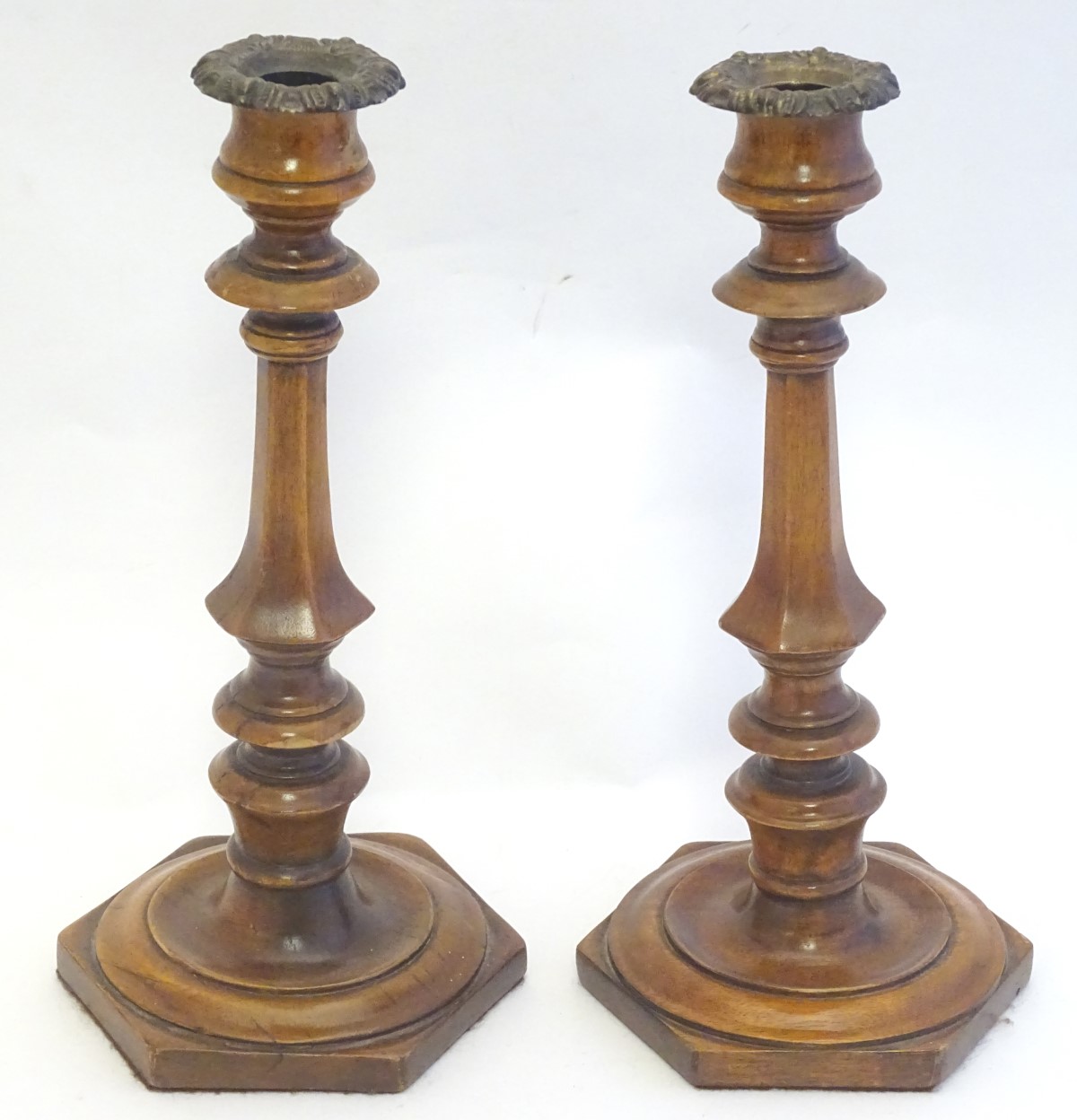 Treen: A pair of 19thC turned and carved wooden candlesticks with hexagonal bases. Approx. 10 3/4"