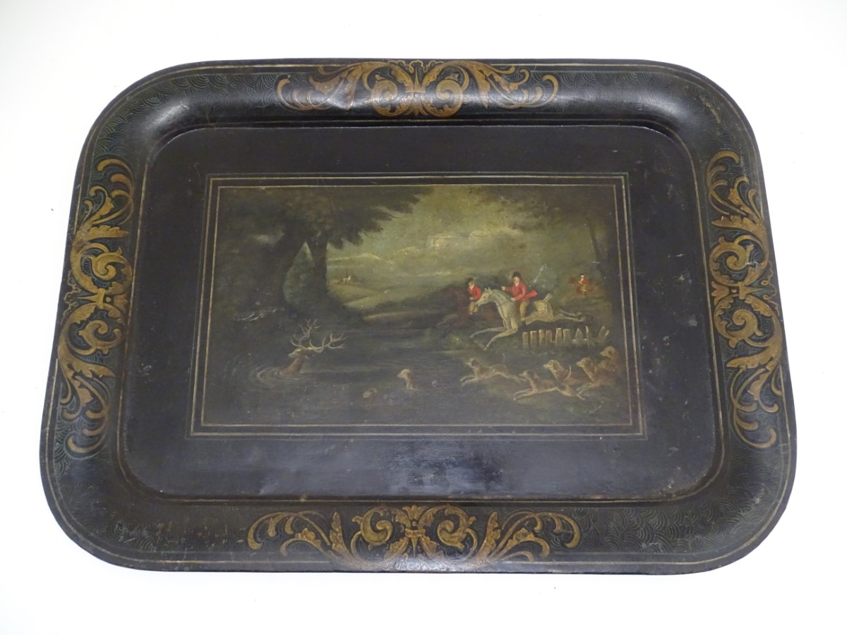 An early 19thC tole peinte tray, decorated with a stag hunting scene, with figures on horseback