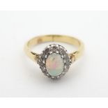 An 18ct gold ring set wit central opal bordered by diamonds. The ring size approx J 1/2" Please Note