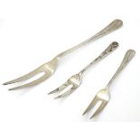 A silver Hanoverian pattern two tine serving fork 9" long together with 2 smaller forks.