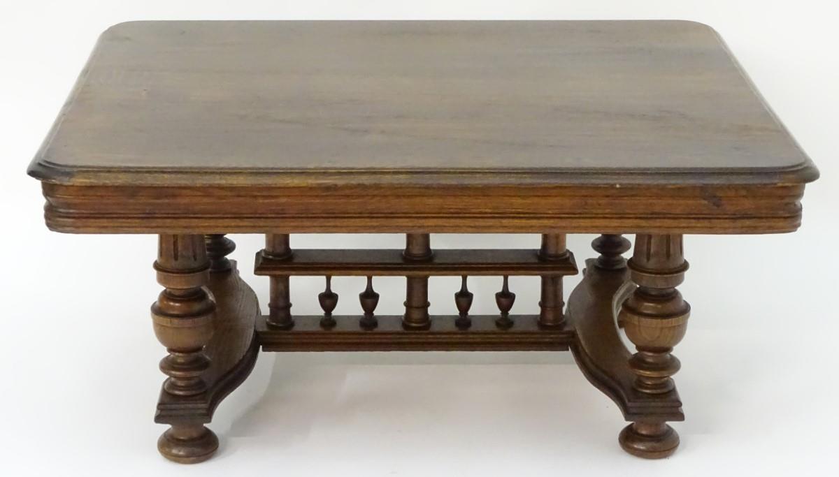 A 20thC oak table with a rectangular moulded top, four turned tapering legs with fluted decoration