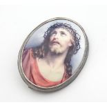 A silver brooch of oval form set with enamel cabochon depicting image of Jesus Christ 1 3/4" long