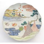 A Chinese plate with a lobed rim, decorated with a landscape with stylised quail birds. Scrolling