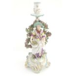 A 19thC candlestick bocage figure, depicting a woman with a basket of flowers raised on a