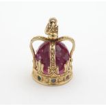 A Continental yellow metal pendant / charm formed as a crown set with facet cut crimson cystal